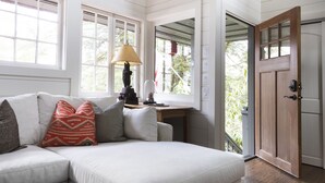 Una sala de estar acogedora con un sofá modular, una lámpara y un escritorio de madera.