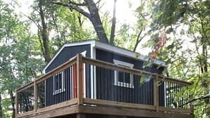 A cabin with a wooden deck, a white chair, and a hammock. - FOOTBALL WEEKEND GET-A-WAY - with outdoor space to die for. (South Bend)
