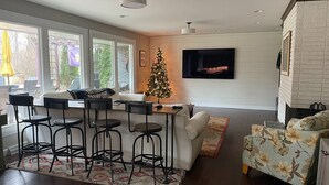 A modern living room with a bar area, a Christmas tree, and a flat-screen TV mounted on the wall. - FOOTBALL WEEKEND GET-A-WAY - with outdoor space to die for. (South Bend)