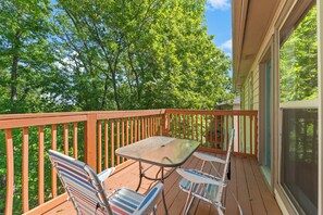 Enjoy a serene outdoor space with a glass table and two chairs, overlooking a lush landscape.