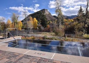 An outdoor swimming pool with a mountain view, surrounded by trees and a fence. - Resort/Spa, Ski in/out, Hot Tub, 8th Fl, RmService (Avon)