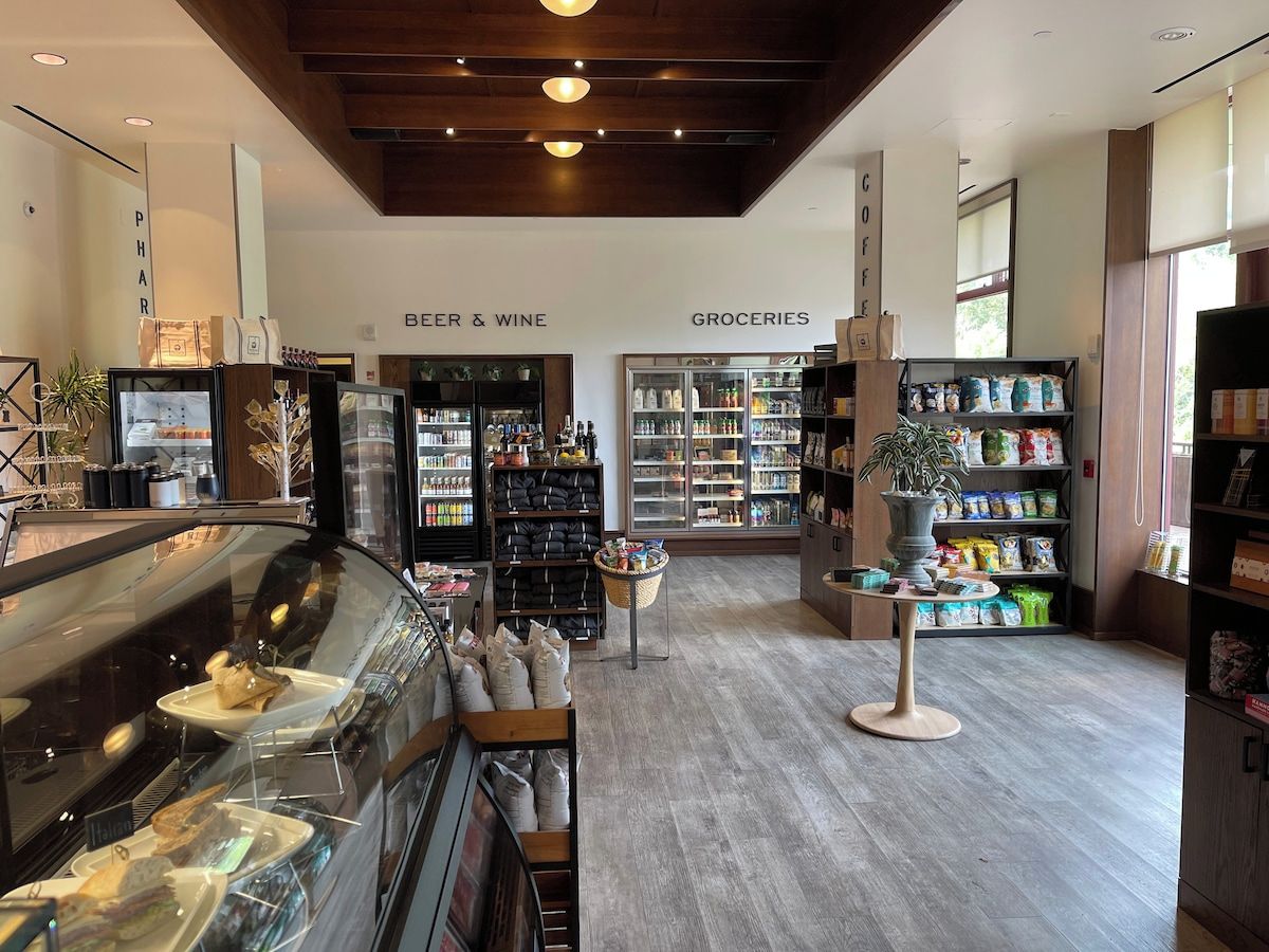 A modern interior with a coffee station, a beer and wine section, and a grocery area.