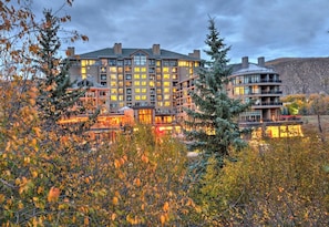 A multi-story hotel with a central courtyard, surrounded by trees and a mountainous backdrop. - Resort/Spa, Ski in/out, Hot Tub, 8th Fl, RmService (Avon)