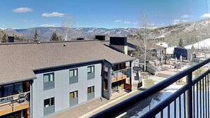 A modern building with a balcony, a view of mountains, and a clear sky. - 🌲Timberline C3B Deluxe 1-Bedroom + Loft ~Hot Tub~Pool~WiFi~Ski-in/out~Local Shuttle🌲 (Snowmass Village)