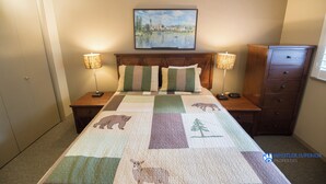 A bedroom with a bed, two bedside tables, a nightstand, a dresser, and a painting on the wall. - Glacier Lodge - Deluxe Ski in/Ski out (Whistler)
