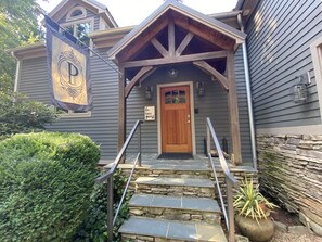 Step into a charming two-story home with a welcoming front porch and a traditional gabled roof.