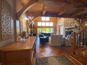 Cozy living area with a stone fireplace, sofa, and armchairs.
