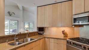 A modern kitchen with granite countertops, stainless steel appliances, and wooden cabinets. - Ski Storage, Garage and Free Shuttle (Warm Springs)