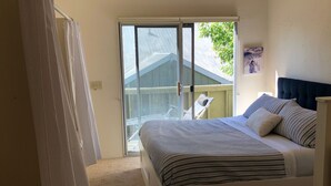 A bedroom with a bed, a ceiling fan, a window with curtains, and a view of the outside. - Iconic Sun Valley - Parkside Village - Sleeps 7 very comfortably  (Ketchum)