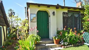 Un petit bâtiment d’un seul étage, avec une porte verte et un petit porche.