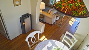 Une pièce chaleureuse comprenant une table à manger, des chaises, une lampe et un petit coin salon avec un canapé et une lampe.