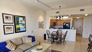 A living room with a sofa, coffee table, and artwork on the wall. - Inn at Dauphin Island 211 Beautiful Views!! (Dauphin Island)