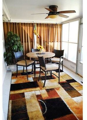 Enjoy meals in this cozy dining area with a round table and four chairs, surrounded by a potted plant and natural light.