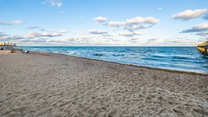 A beach with a sandy shore and a pier extending into the water. - SPECIALS!! BEAUTIFUL BEACH HOUSE ! WALK 2 BEACH POOL ! HOT TUB (Lauderdale-By-The-Sea)