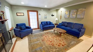 Un salon avec deux canapés bleus, une table basse et un tapis à motifs.