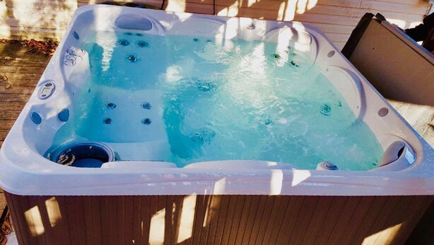 Un bain à remous sur une terrasse en bois.