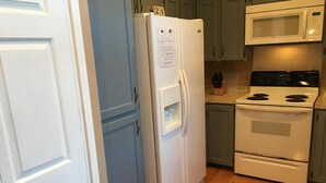 A kitchen with a white refrigerator, a microwave, and a stove.