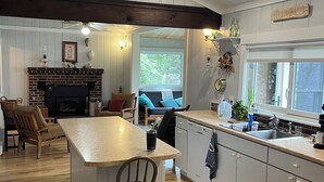 Una cocina amplia con una isla central, suelo de madera y estufa integrada.