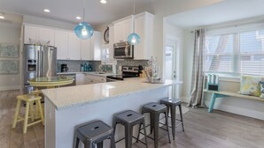 A modern kitchen with a central island, stainless steel appliances, and pendant lighting. - Mermaid Cove: Updated Forida Cottage w/pool, hot tub (Anna Maria)