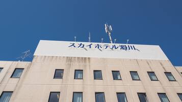 Een gebouw met een bord in Japanse karakters en meerdere antennes op het dak.