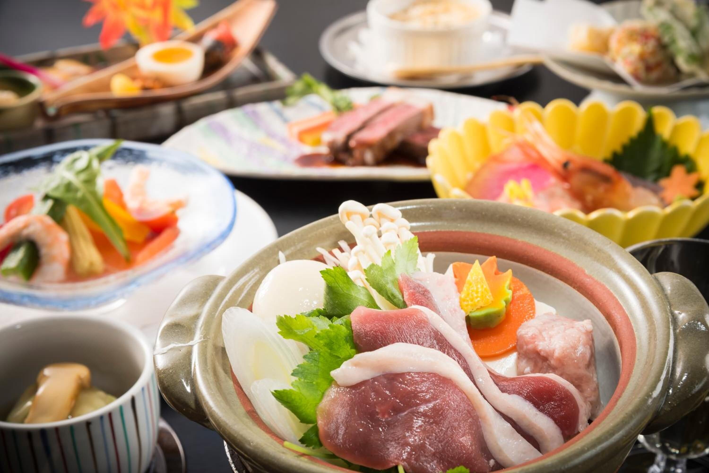 Diversos plats, com sashimi i sushi, presentats sobre una taula amb plats i cuplets múltiples.