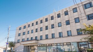 A multi-story hotel with a modern design, featuring a central entrance with a glass facade and a covered area. - Sky Hotel Namerikawa (Namerikawa)