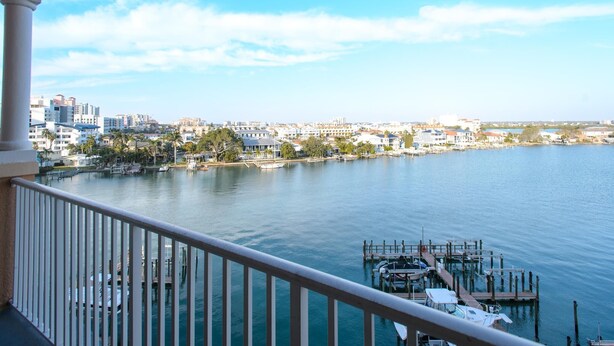 A balcony with a view of a marina and cityscape.
