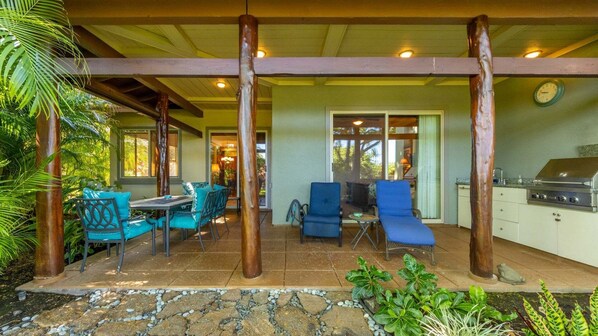 An outdoor patio area with a grill, seating, and a view of the interior. - Tropical Villa w/Beach Club Access ★Quiet Location★Bikes and Beach Gear★Walk to Restaurants (Kamuela)