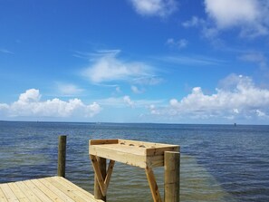 A wooden pier extending into calm waters with a clear sky above. - Waterside: Soundfront condo with spectacular sunsets. (Ocracoke)