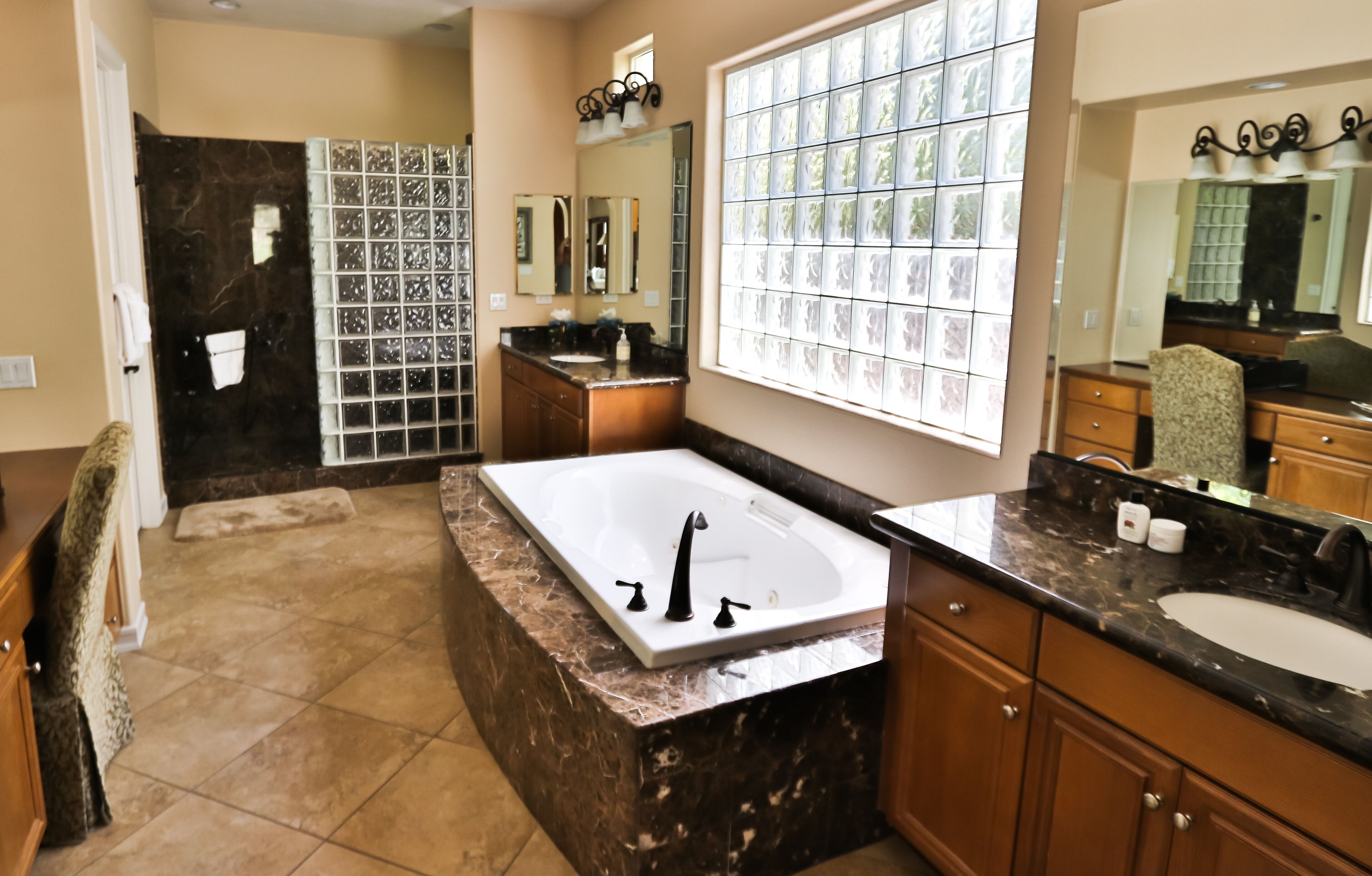 A bathroom with a large bathtub, a vanity with a sink, and a shower area.