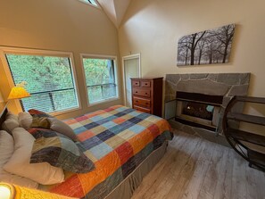 A bedroom with a bed, dresser, windows, and a fireplace. - On Blackcomb Mountain - Balcony w/ BBQ, Common Rooftop Hot Tub, Free Parking (Whistler)