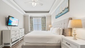 A hotel room with a large bed, a television, a ceiling fan, and a window with curtains. - Liberty Sky: Private Pool, Water Park, Golf View, Near Disney (Kissimmee)