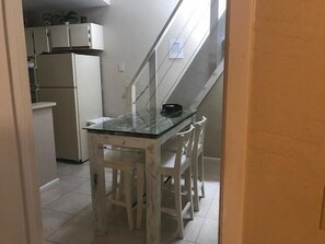 Eine kleine Küche mit weißen Schränken und einem Kühlschrank.