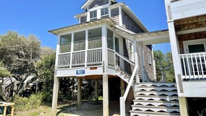 A two-story house with a balcony and a covered porch. - Secret Cedars: Soundfront, perfect kayaking or water activities. (Ocracoke)