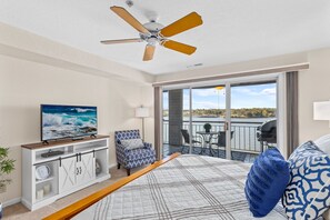 Relax in this stylish living room with a large flat-screen TV, comfortable seating, and a balcony offering scenic views.