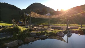 A serene outdoor setting with a pond, picnic tables, and a shaded area. - "Stylish and Comfortable One bedroomed Apartment in söll - Sleeps up to 4!" (Söll)