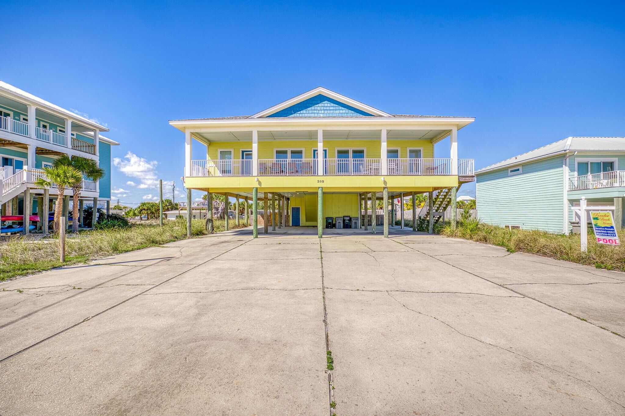 A two-story building with a balcony, a covered entrance, and a sign indicating a pool.