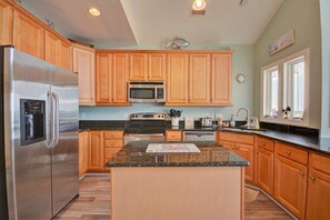 Enjoy cooking in this well-equipped kitchen with a central island, sink, and stainless steel appliances.
