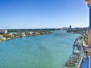 Blick auf einen Hafen mit Booten, Gebäude an der Küste und einem klaren Himmel.