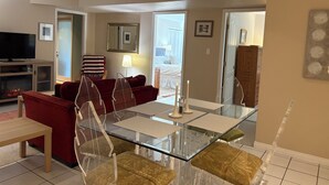 Ein modernes Wohnzimmer mit einem Glastisch, roten Sofas und einem Fernseher.
