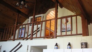 Een houten interieur met een vide, witte kasten en een trap.