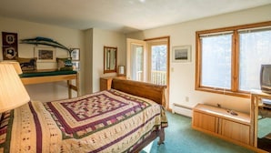 A bedroom with a bed, a desk, a television, and a window with a view. - Three bedroom townhouse, conveniently located (Killington)
