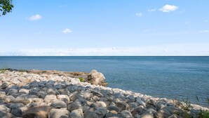Un rivage rocheux, avec une mer calme en arrière-plan.