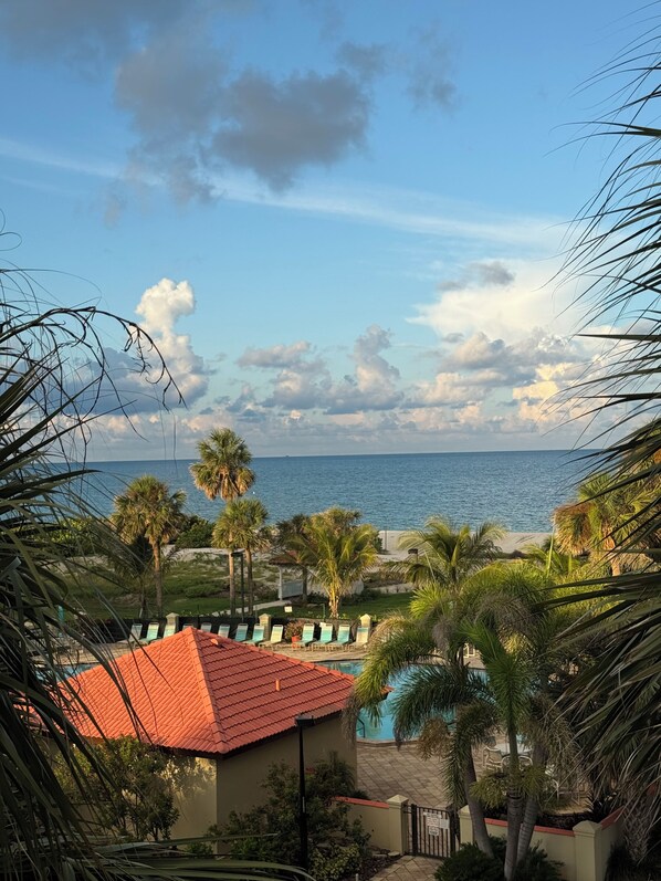 A beachfront property with a swimming pool, palm trees, and a view of the sea. - Land's End #403 Building 1 - Oceanfront View (Treasure Island)