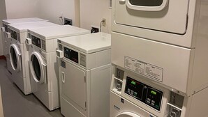 A laundry facility with multiple stacked washing machines and dryers.