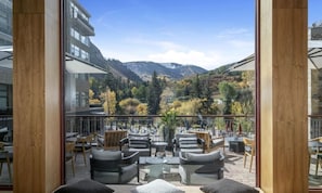 A balcony with outdoor seating, a mountain view, and a glass wall. - Charlie Rentz: Riverfront Resort/Spa, Ski-In/Out Penthouse, Ski Valet, Private Balcony #914 (Avon)