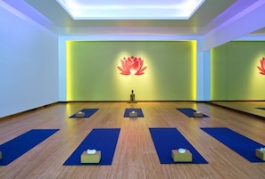 A yoga studio with a mirrored wall, a lotus symbol, and yoga mats arranged on the floor. - Charlie Rentz: Riverfront Resort/Spa, Ski-In/Out Penthouse, Ski Valet, Private Balcony #914 (Avon)