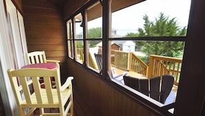 Een houten terras met een tafel en stoelen, met uitzicht op een woongebied.