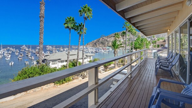 A balcony with a view of a marina and palm trees.