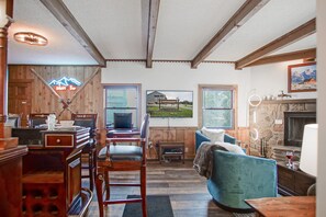 Un salon chaleureux avec une cheminée, des meubles en bois et une grande fenêtre donnant sur un immeuble.